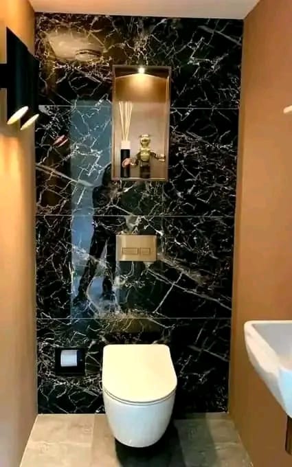 Completed guest bathroom clad in black marble tiles