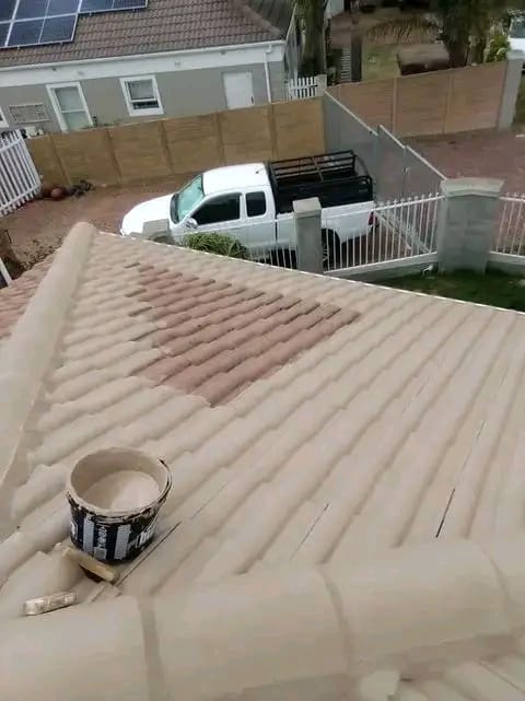 Roof coating being applied to concrete tiles